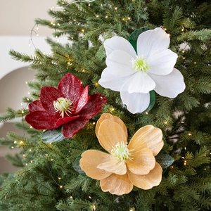 Glittery artificial lotus and magnolia flowers in pearl white and red on a Christmas tree