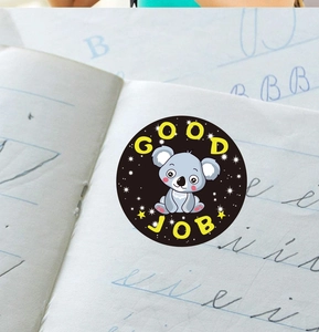 Close-up of cute cartoon koala reward sticker with Good Job text on notebook