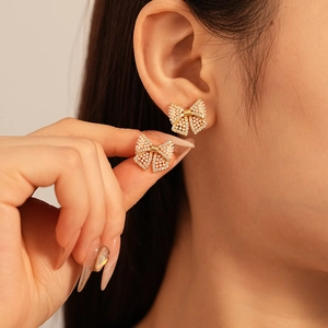 Elegant bow stud earrings with small imitation pearls and zircons in gold-plated finish