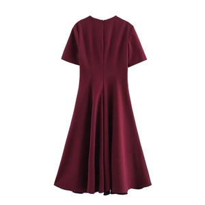 Detail of wine red midi dress showing the waist cinch and wide A-line hem draping