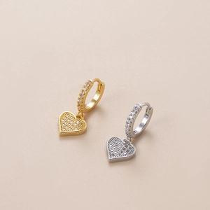Close-up of gold and silver heart earrings with sparkling cubic zirconia inlay