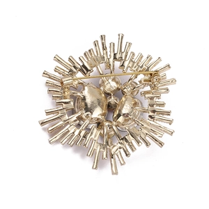Back view of a gold-tone baroque brooch with rhinestones and pearl setting on white background