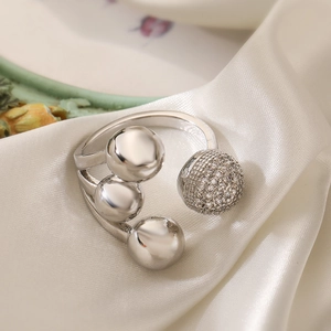 Irregular geometric silver ring with zircon spheres on elegant white silk background