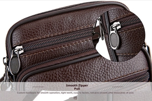 Detail of dark brown leather crossbody bag featuring durable smooth metal zippers