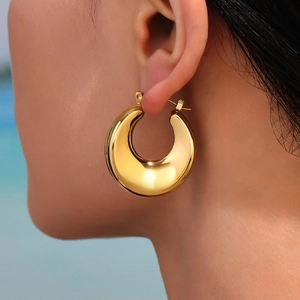 Grosse boucle d'oreille créole en acier inoxydable plaqué or 18 carats sur mannequin