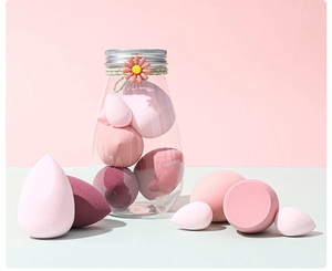 Nahaufnahme von rosa Make-up-Schwämmen in verschiedenen Formen in einem Glasbehälter