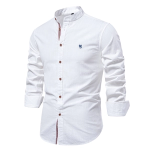 Détail de chemise en lin blanc avec col montant, broderie et bordure de patte contrastée
