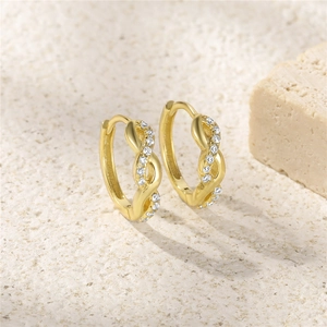 Detailed close-up of gold-plated twisted earrings with pavé-set white zircon stones