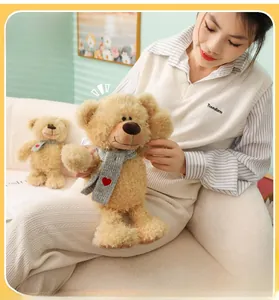 Detalle de un osito de peluche crema con bufanda gris de corazón en un cálido entorno hogareño
