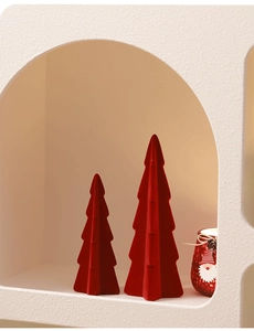 Close-up of red flocked Christmas tree ornaments on a minimalist beige display shelf