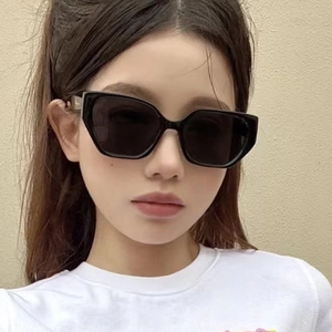 Polygonal oversized sunglasses with wide temples and dark lenses on fashion model