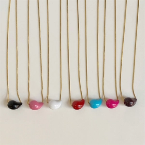 Detailed view of colorful glossy teardrop pendants on elegant gold chains in various shades