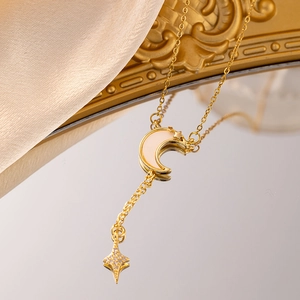 Elegant gold celestial necklace featuring a star and moon pendant on a mirror