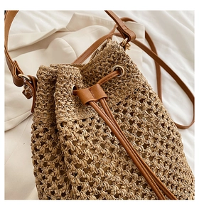 Detailed view of the brown paper rope woven bucket bag with leather strap and texture