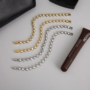 Detailed flat lay of gold and silver tennis bracelets with heart and round zircon settings