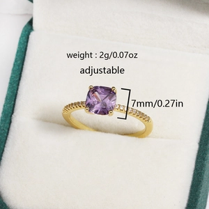 Macro shot of an adjustable gold ring with square purple zircon and side diamond accents