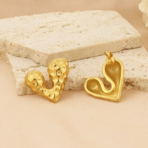 18k gold plated stainless steel heart earrings with hammered texture on stone background