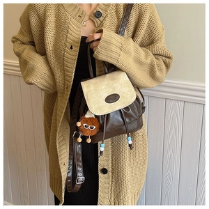 Close-up of retro PU leather backpack with drawstring closure and plush pendant detail