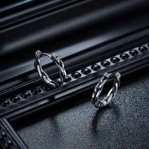 Detailed macro view of vintage twisted titanium steel hoop earring with metallic finish
