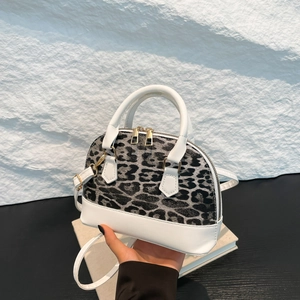 Fashionable leopard print shell bag with white leather straps and gold zippers