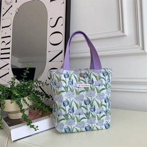 Dettaglio della borsa in tela floreale con tulipani blu e cinturino viola