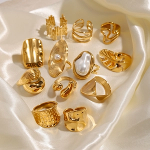 Set of 11 irregular 18k gold plated stainless steel rings with pearls on silk background