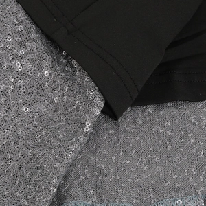 Détail macro du tissu en maille noire avec dentelle à paillettes argentées scintillantes