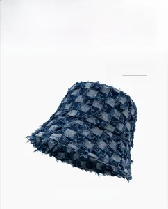Close-up of navy blue checkered denim bucket hat with frayed edges and street style texture