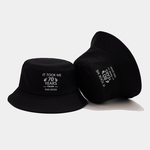 Black cotton bucket hat with white 70th birthday slogan print for outdoor sun protection