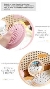 Detailansicht der faltbaren Haarbürste mit integriertem Spiegel und rosa Massage-Luftkissen