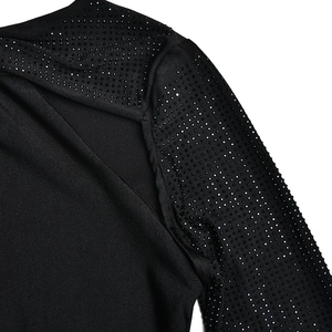 Gros plan des strass brillants sur l'épaule et la manche de la robe noire sexy
