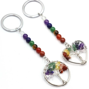 Detail of tree of life keychains with round and heart pendants made of colorful chakra stones