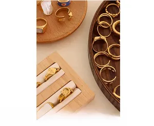 Close-up of vintage gold rings with pearl and mother-of-pearl accents on a wooden display