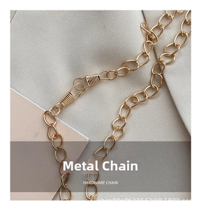 Close-up of a polished golden metal chain strap with secure spring hooks for handbags