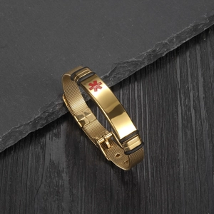 Close-up of gold mesh medical alert bracelet with red Star of Life symbol on stone base