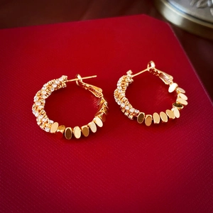 Detailaufnahme goldener Creolen mit Zirkonia-Pavé in einer hochwertigen Geschenkbox
