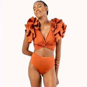 Close-up of rust red high waisted bikini bottoms and ruffled shoulder details on swimsuit