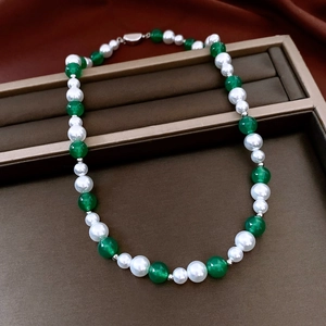 Detail of vintage necklace with green agate beads, white pearls and silver clasp