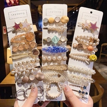 Detailed close-up of a diverse hair clip set featuring pearls, acrylics, and gold metal finish