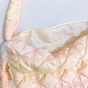 Detail view of the pink gradient quilted cloud bag showing zipper closure and inner pocket