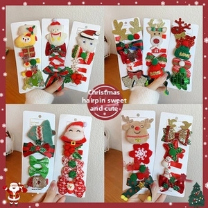 Detail of Christmas hair clip set with plush reindeer and festive tree ornaments