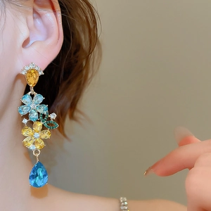 Detail of flower drop earrings with blue and yellow gemstones and crystal petal accents