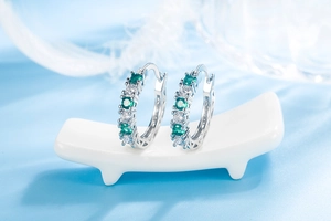 Macro detail of emerald and white cubic zirconia stones in silver claw setting