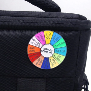 Detail of creative rainbow mood wheel enamel pin on black bag with inspirational phrases