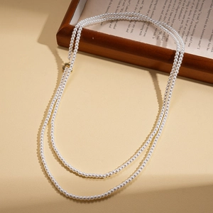 Detailed macro view of vintage faux pearl strands with a golden flower-shaped OT clasp toggle