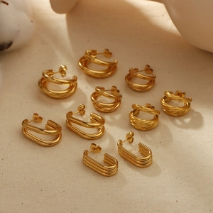 Minimalist 18k gold plated stainless steel multi-layered C-shape hoop earrings on beige fabric