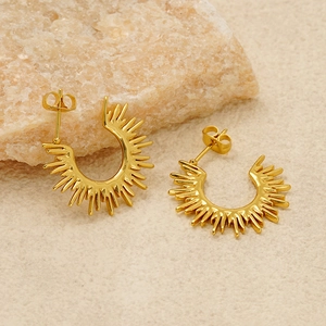 Elegant gold fan-shaped sunflower C-hoop earrings displayed on a textured stone