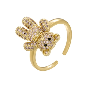 Macro shot of gold ring featuring a 3D teddy bear inlaid with sparkling pink rhinestones
