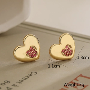 Detail view of 18K gold plated heart stud earrings with pink stones measuring 1.3cm wide