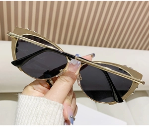 Detail of gold cat-eye sunglasses featuring sparkling rhinestones and dark lenses